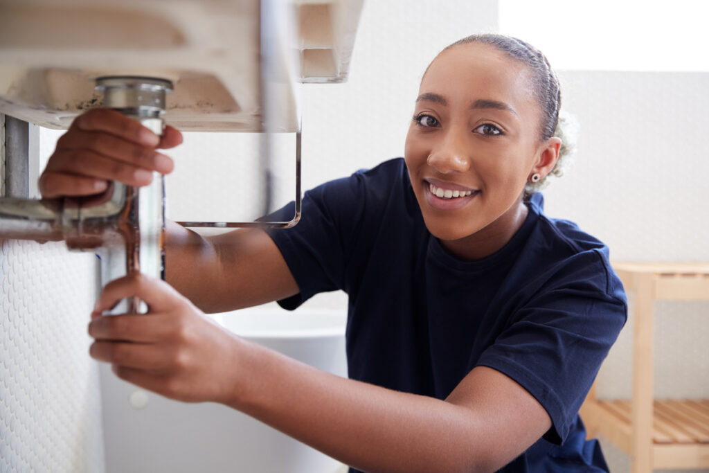 female plumber ensuring there is no leak in the pipe