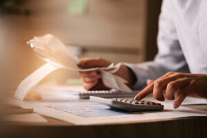 Close up of business accountant using calculator while working i